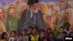 Venezuelan children gather in front of a poster of Iranian Supreme Leader Ayatollah Ali Khamenei at the International Fair of Venezuelan-Iranian Culture and Friendship in Caracas, March 2023. (IRNA)