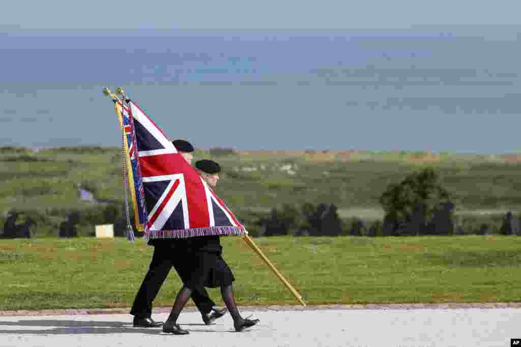 Youth carry the Union Flag during a commemorative ceremony marking the 80th anniversary of the World War II D-Day&quot; Allied landings in Normandy, at the World War II British Normandy Memorial of Ver-sur-Mer, June 6, 2024.&nbsp;