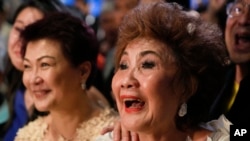 Janet Yeoh, right, mother of Michelle Yeoh, celebrates after her daughter won in the best actress category during the 95th Academy Awards in Los Angeles, as seen in a live view event at a cinema in Kuala Lumpur, Malaysia, March 13, 2023.