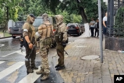 Servicemen of the Wagner Group military company guard an area at the HQ of the Southern Military District in a street in Rostov-on-Don, Russia, June 24, 2023.