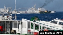 Kapal Garda Pantai China mengerahkan meriam ke arah kapal Unaizah yang disewa oleh militer Filipina untuk membawa pasokan ke beting Second Thomas Shoal di Laut China Selatan, 5 Maret 2024. (Foto: Jam Sta Rosa/AFP)