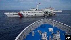 FILE - Chinese coast guard ships block Philippine coast guard BRP Cabra as it tried to head towards Second Thomas Shoal, locally known as Ayungin Shoal, at the disputed South China Sea during a rotation and resupply mission on Aug. 22, 2023. 