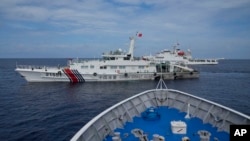 Kapal Garda Pantai China menghalangi penjaga pantai Filipina BRP Cabra saat kapal tersebut mencoba menuju Second Thomas Shoal di Laut China Selatan yang disengketakan pada 22 Agustus 2023. (Foto: AP)