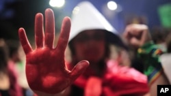 An abortion rights activist, her hand painted red, takes part in a march against an anti-abortion congressional bill in Sao Paulo, June 15, 2024.
