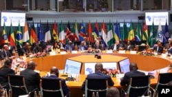 FILE - German Chancellor Olaf Scholz, center, presides over the "Compact with Africa" investment summit in Berlin, Nov. 20, 2023. The German government pledged to invest 4 billion euros in African green energy projects through 2030.