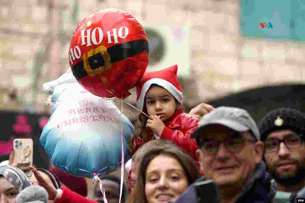  Una niña vestida con motivos navideños observa el desfile de Navidad celebrado el pasado año 2022, en la ciudad de Belén. Este año, la tierra donde nació Jesús ha suspendido todos los festejos en solidaridad con las víctimas de la guerra en Gaza. &nbsp; 