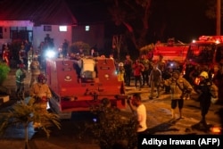 Kendaraan pemadam kebakaran tak berawak yang dikendalikan dari jarak jauh bergerak menuju pintu masuk gudang amunisi militer tempat beberapa ledakan terjadi di Gunung Putri Jawa Barat pada 31 Maret 2024. (Foto: Aditya Irawan/AFP)