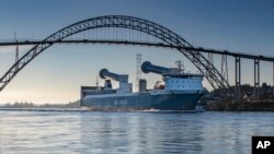 FILE - 2021 photo of the freight vessel, SC Connector, passing beneath the Karmsund Bridge in Haugesund, Norway. The ship's rotor sails tilt to avoid overhead bridges or power lines.