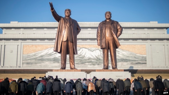 북한 주민들이 지난해 2월 평양 만수대 언덕의 김일성(왼쪽)·김정일 부자 동상을 참배하고 있다. (자료사진)