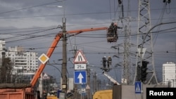 (FILE) Energy supply workers restore a high-voltage line destroyed in Russian missile attack, amid Russia's attack on Ukraine, in Kyiv.