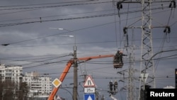 FILE - Energy supply workers restore a high-voltage line destroyed in Russian missile attack, amid Russia's attack on Ukraine, in Kyiv, Feb. 7, 2024.