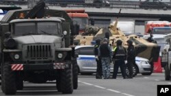 An APC and police officers stand on the highway on the outskirts of Moscow, Russia, June 24, 2023.