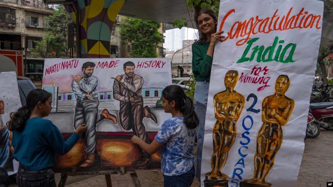 Siswa sekolah seni membuat lukisan di trotoar untuk merayakan kemenangan dua penghargaan Oscar di Mumbai, India, Senin, 13 Maret 2023.(Foto AP/Rafiq Maqbool)