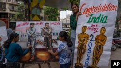 Siswa sekolah seni membuat lukisan di trotoar untuk merayakan kemenangan dua penghargaan Oscar di Mumbai, India, Senin, 13 Maret 2023.(Foto AP/Rafiq Maqbool)