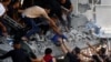 Palestinianos resgatam criança de escombros em edifício destruído por bombardeamentos israelitas, 24 outubro 2023