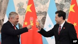 Honduras Foreign Minister Eduardo Enrique Reina Garcia, left, and Chinese Foreign Minister Qin Gang, raise a toast following the establishment of diplomatic relations between the two countries, at a ceremony in Beijing, March 26, 2023. (Greg Baker/Pool Photo via AP)