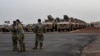 FILE - American soldiers stand in front of military vehicles to be loaded onto cargo planes in Niamey, Niger, June 7, 2024, as U.S. troops prepare for their withdrawal from the country.