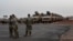 FILE - American soldiers stand in front of military vehicles to be loaded onto cargo planes in Niamey, Niger, June 7, 2024, as U.S. troops prepare for their withdrawal from the country.