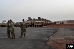 FILE - American soldiers stand in front of military vehicles to be loaded onto cargo planes in Niamey, Niger, on June 7, 2024, as U.S. troops prepare for their withdrawal from the country.