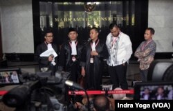 Kuasa hukum penggugat batas maksimal umur capres, Anang Suindro (tengah) memberikan keterangan pers setelah sidang putusan MK yang menyatakan gugatannya ditolak, Senin (23/10). (VOA/Indra Yoga)
