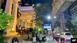 People walk outside a hotel where a number of people were found dead in Bangkok, Thailand, July 16, 2024. 