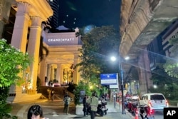 Orang-orang berjalan di luar hotel tempat sejumlah orang ditemukan tewas di Bangkok, Thailand, Selasa, 16 Juli 2024. (AP Photo/Napat Kongsawad)