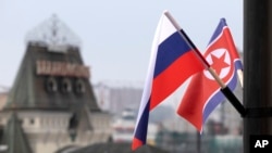 FILE - Flags of Russia and North Korea are seen in front of the central railway station in Vladivostok, Russia, April 24, 2019, ahead of a summit in the city between Russian President Vladimir Putin and North Korean leader Kim Jong Un.