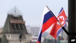 FILE - Russian and North Korean flags wave in Vladivostok, Russia, before a summit between Russian and North Korean leaders, April 24, 2019. White House national security spokesman John Kirby said the U.S. believes arms negotiations between Russia and North Korea are advancing. 