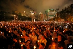 FILE - Thousands of people attend a candlelight vigil for victims of the Chinese government's brutal military crackdown three decades ago on protesters in Beijing's Tiananmen Square at Victoria Park in Hong Kong, on June 4, 2019.