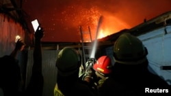 Petugas pemadam kebakaran berusaha memadamkan api di stasiun penyimpanan bahan bakar yang dioperasikan oleh Pertamina, di Plumpang, Jakarta, 3 Maret 2023. (REUTERS/Willy Kurniawan)