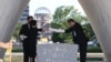 在廣島和平紀念公園舉行的儀式上，廣島市長松井一實和死者家屬代表將原子彈爆炸遇難者名單安放在紀念碑上。 (2023年8月6日)