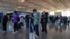 중국 베이징 서우두 국제 공항에서 마스크를 쓴 여행객들이 해외 여행 수속 카운터에서 건강 기록을 작성하고 있다. (자료사진) 
