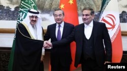 Diplomat senior China Wang Yi memediasi pertemuan Menteri Negara dan Nasional penasihat keamanan Arab Saudi Musaad bin Mohammed Al Aiban (kiri) dan Ali Shamkhani (kanan), sekretaris Dewan Keamanan Nasional Tertinggi Iran, selama pertemuan di Beijing, China 10 Maret 2023.