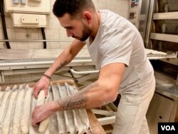 FILE - A Paris baker prepares a baguette for the oven. The quintessential loaf has made it on UNESCO's intangible cultural heritage list. (Lisa Bryant/VOA)