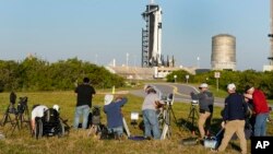 Photographers set up cameras to cover the launch of the SpaceX Falcon 9 rocket with the crew capsule Endeavour as it stands ready at the Kennedy Space Center in Cape Canaveral, Florida, Feb. 26, 2023.