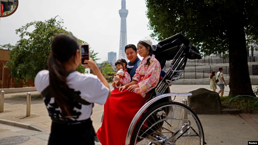 Penarik becak Akina Suzuki, 19 tahun, mengambil foto keluarga turis dari Taiwan selama ia menjadi pemandu tur bagi keluarga itu di sekitar distrik Asakusa di Tokyo, Jepang (foto: dok).