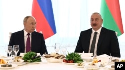 Russian President Vladimir Putin, left, and Azerbaijani President Ilham Aliyev attend a state reception at the Gulustan Palace in Baku, Azerbaijan, Aug. 19, 2024. (Sputnik via AP)