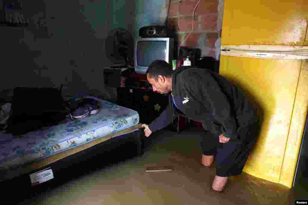 Construction worker Nicelio Goncalves, 52, shows the interior of his flooded house after heavy rains in Duque de Caxias, Rio de Janeiro state, Brazil.