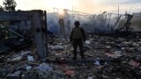 A police official looks at the damage to an industrial area in the Ukrainian capital of Kyiv, after a massive overnight missile attack to Ukraine on Sept. 21, 2023. 