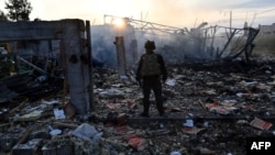 A police official looks at the damage to an industrial area in the Ukrainian capital of Kyiv, after a massive overnight missile attack to Ukraine on Sept. 21, 2023. 