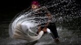 A washerman cleans clothes on the banks of the Brahmaputra River on World Water Day in Guwahati, India, March 22, 2023.