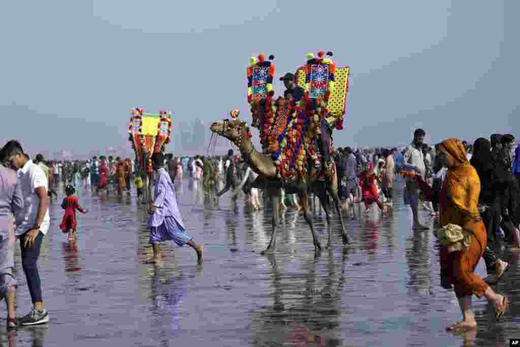 Families visit Clifton beach to celebrate the Eid al-Fitr holidays, marking the end of the Islamic holy fasting month of Ramadan, in Karachi, Pakistan.