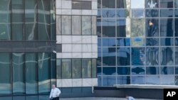 Investigators examine an area next to a damaged building in the "Moscow City" business district after a reported drone attack in Moscow, Russia, Aug. 1, 2023. 