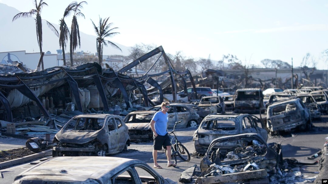 A man walks through wildfire wreckage in Lahaina, Hawaii, Aug. 11, 2023. Hawaii emergency management records show no indication that warning sirens sounded before people ran for their lives from wildfires on Maui that wiped out a historic town.