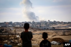 Anak laki-laki menyaksikan asap mengepul selama serangan Israel di timur Rafah di Jalur Gaza selatan pada 13 Mei 2024. (Foto: AFP)