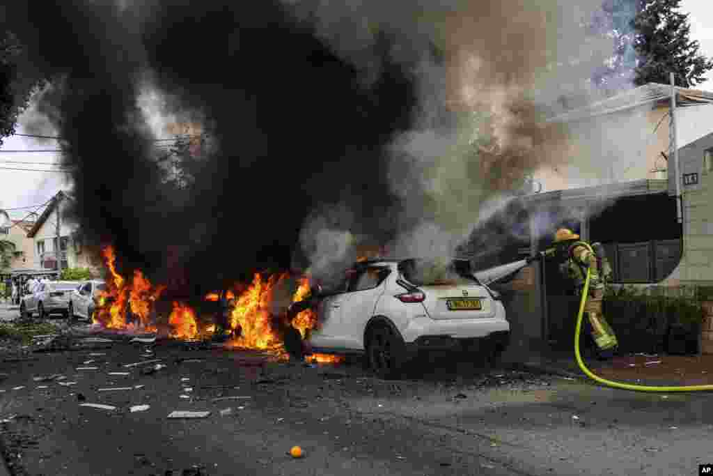 Israeli firefighters extinguish fire at a site struck by a rocket fired from the Gaza Strip, in Ashkelon, southern Israel.