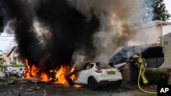 Zjarrfikësit izraelitë shuajnë zjarrin e shkaktuar nga një raketë e lëshuar nga Rripi i Gazës. Ashkelon, Izraeli jugor, 9 tetor 2023.