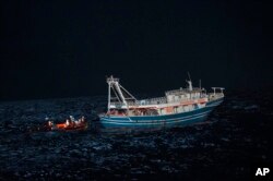 Awak kapal penyelamat Geo Barents mendekat dengan perahu nelayan di perairan internasional lepas pantai Libya Selasa, 4 April 2023. (AP/Salvatore Cavalli)