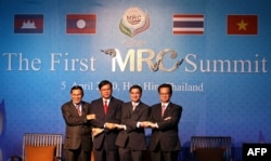 FILE - Leaders from Cambodia, Laos, Thailand and Vietnam link arms during the opening ceremony of the Mekong River Commission Summit in Hua Hin, April 5, 2010.