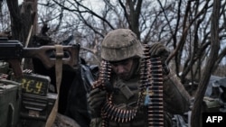 Украинский солдат готовит боеприпасы для обстрела российских передовых позиций близ Бахмута, в Донецкой области Украины, 11 марта 2023 года.